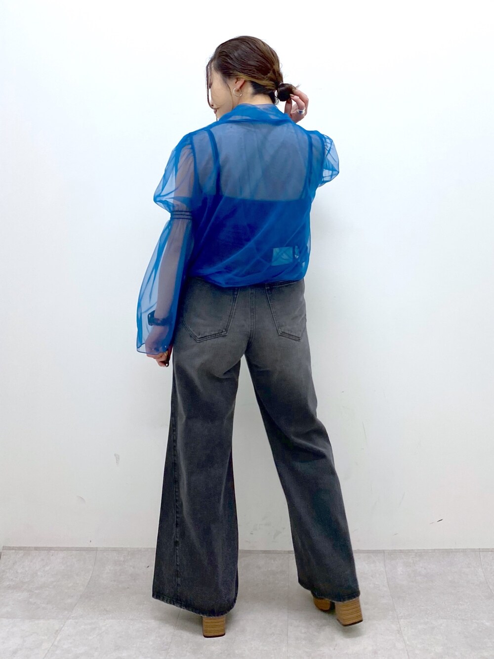 グレー系のテーラードジャケット、ブルー系のシャツ/ブラウス、ブラック系のデニムパンツを着用したレディースの秋コーディネートの6枚目の写真