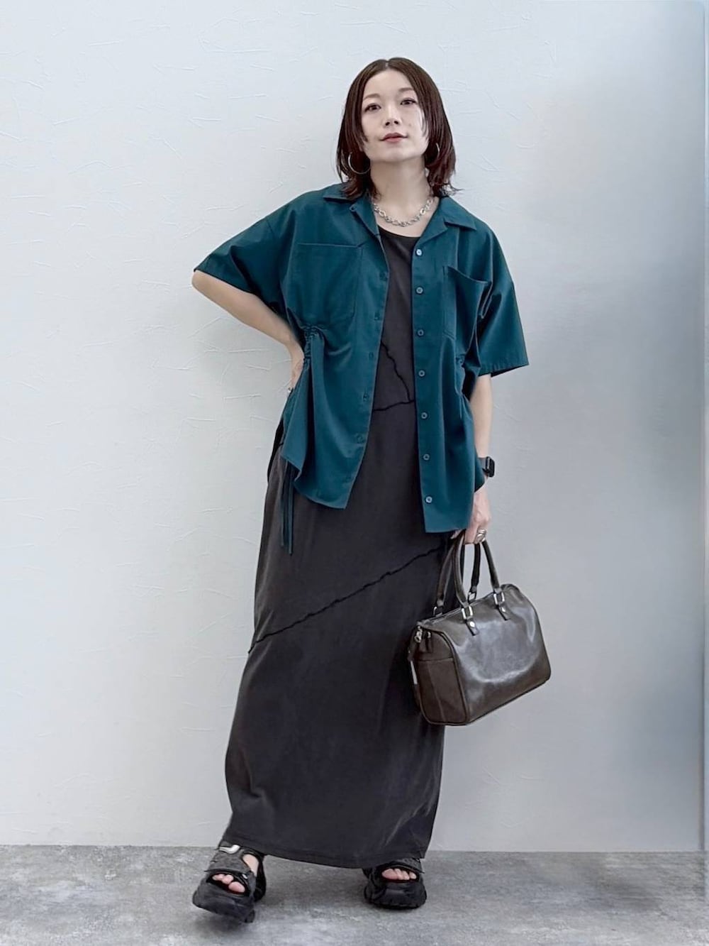 ブラック系のワンピース、グレー系のショルダーバッグ、グリーン系のシャツ/ブラウスを着用したレディースの春コーディネートの9枚目の写真