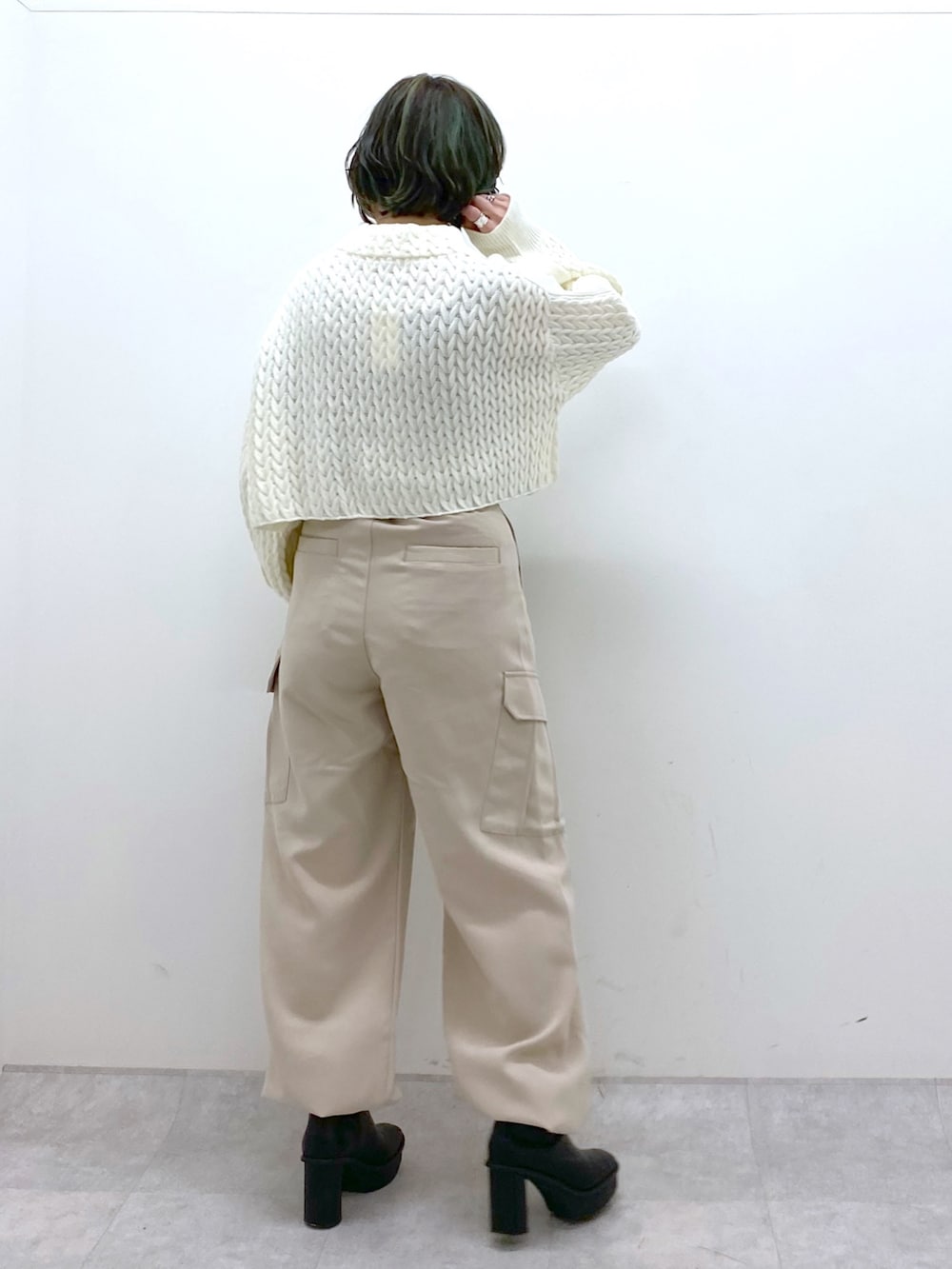 ベージュ系のカーゴパンツ、ホワイト系のニット/セーター、ブラック系のブーツを着用したレディースの冬コーディネートの4枚目の写真