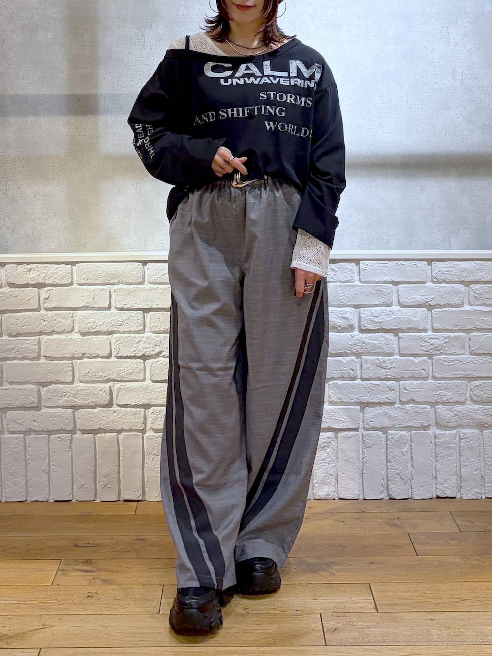 ブラック系のスニーカー、グレー系のその他パンツ、ホワイト系のTシャツ/カットソーを着用したレディースの冬コーディネートの3枚目の写真