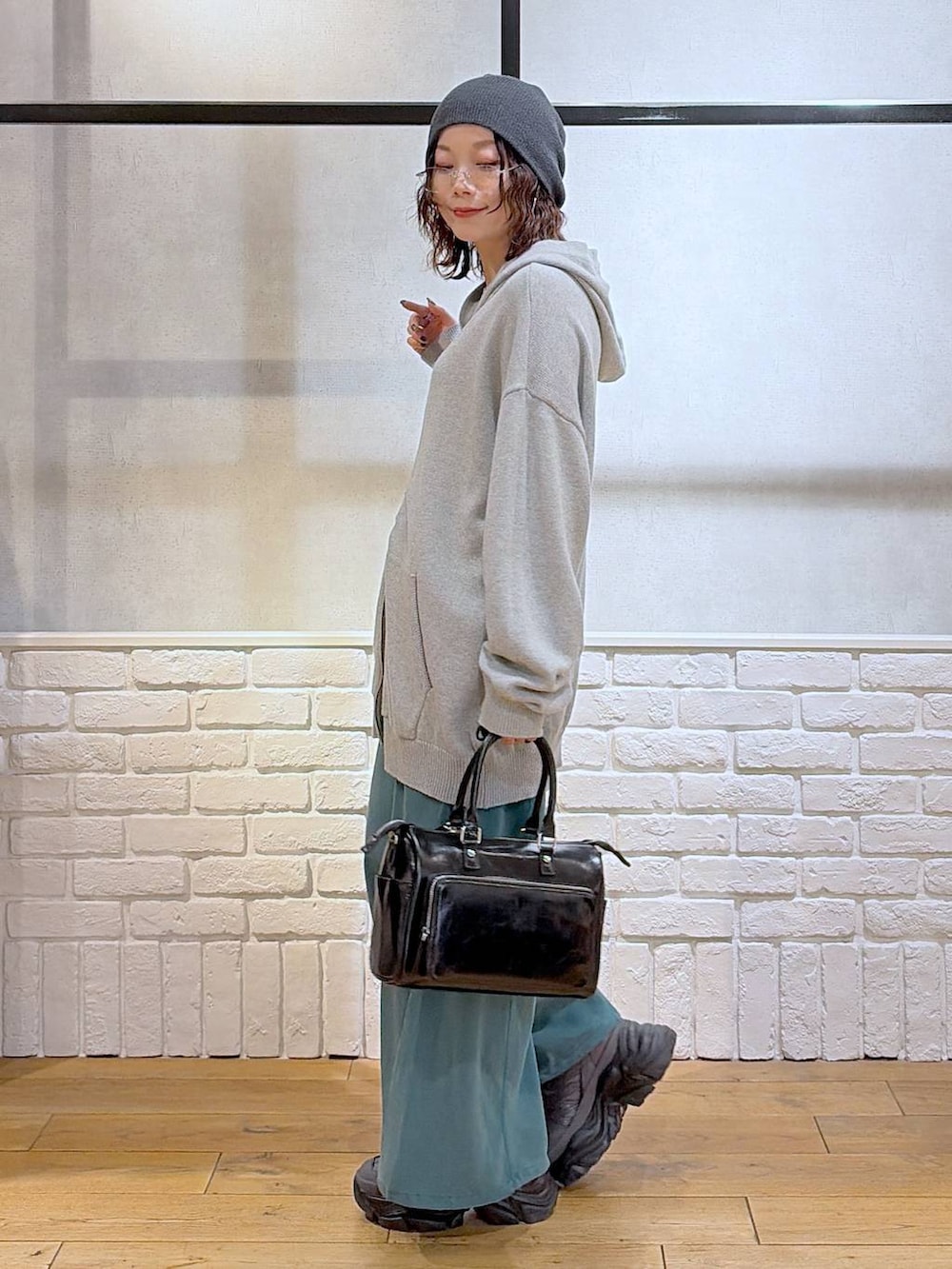グレー系のスニーカー、グレー系のパーカー、ブラック系のショルダーバッグを着用したレディースの春コーディネートの7枚目の写真