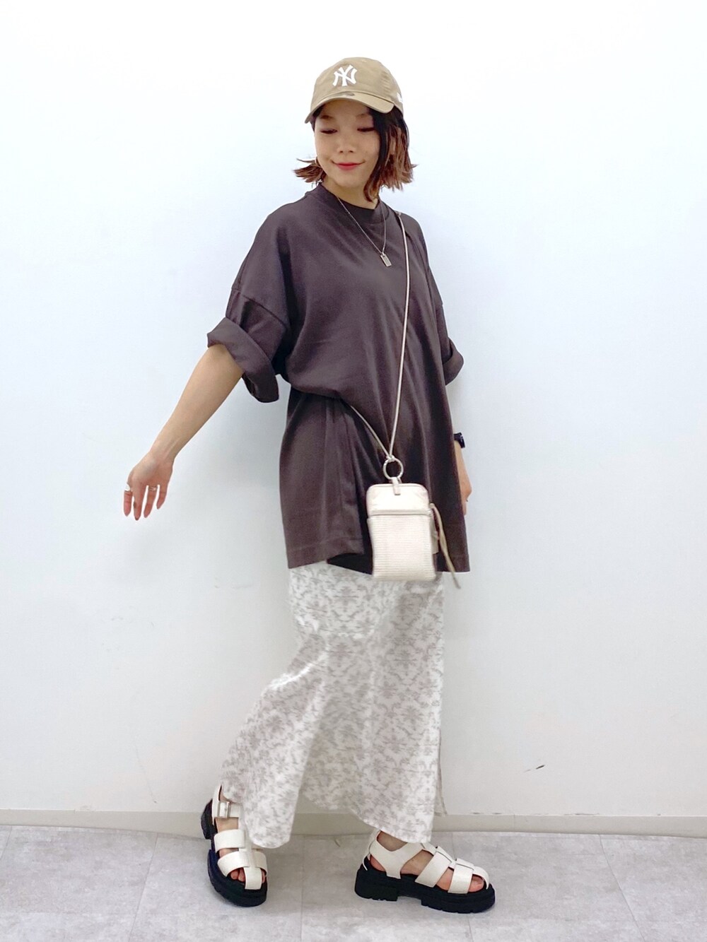 ブラウン系のTシャツ/カットソー、グレー系のスカート、ベージュ系のショルダーバッグを着用したレディースの夏コーディネートの5枚目の写真