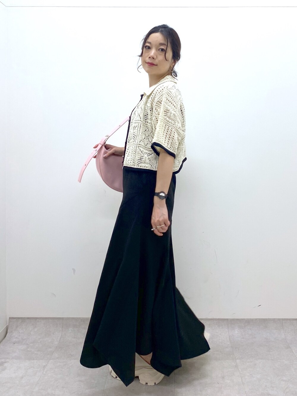 ブラック系のスカート、ホワイト系のカーディガン/ボレロ、ピンク系のショルダーバッグを着用したレディースの夏コーディネートの5枚目の写真