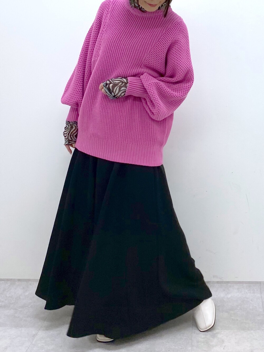 ピンク系のニット/セーター、ブラック系のスラックス、ブラック系のトップスを着用したレディースの冬コーディネートの4枚目の写真