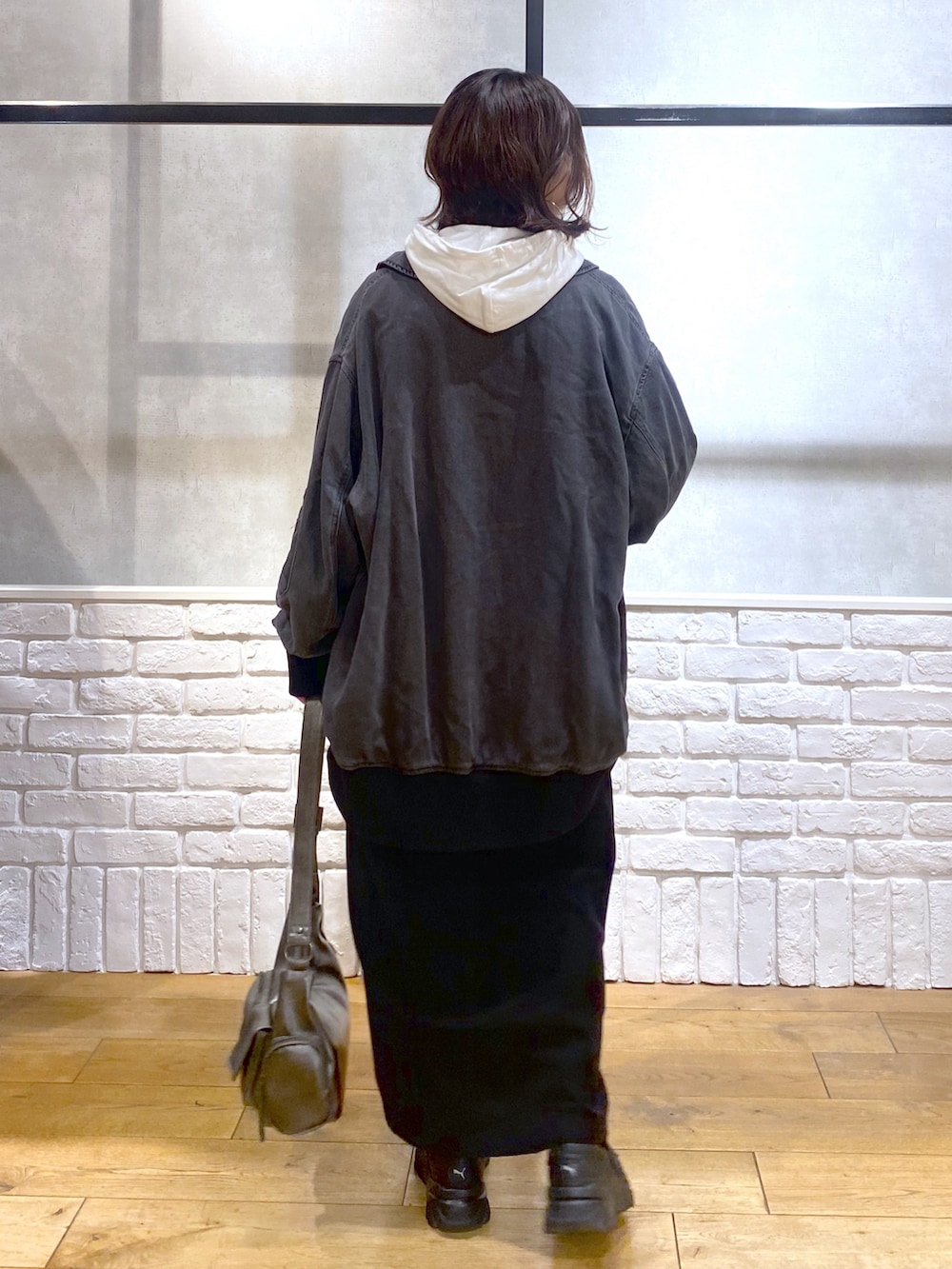 ブラック系のブルゾン、ブラック系のワンピース、ブラック系のローファーを着用したレディースの秋コーディネートの7枚目の写真