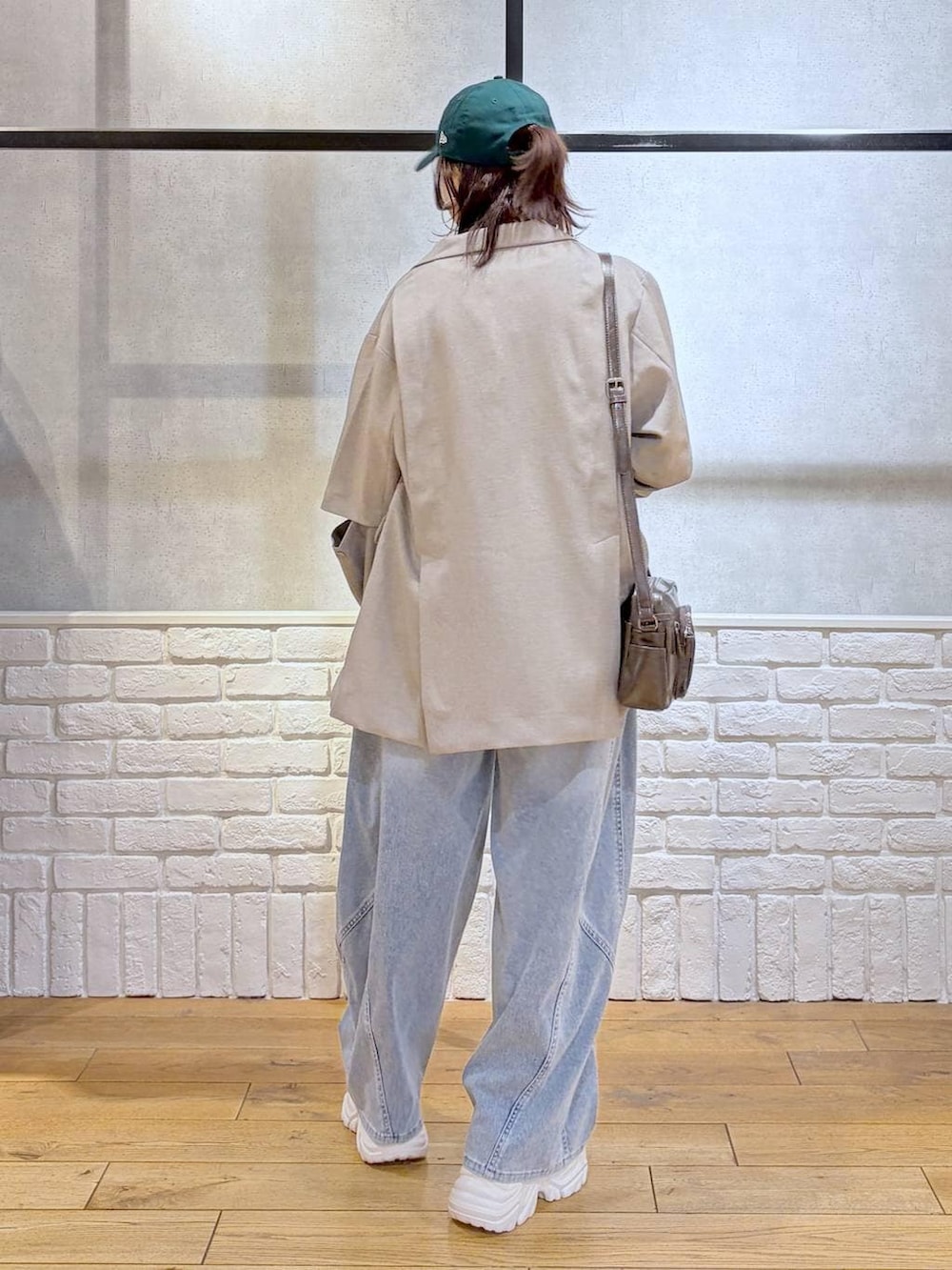 ホワイト系のスニーカー、ホワイト系のタンクトップ、ブラウン系のショルダーバッグを着用したレディースの春コーディネートの6枚目の写真