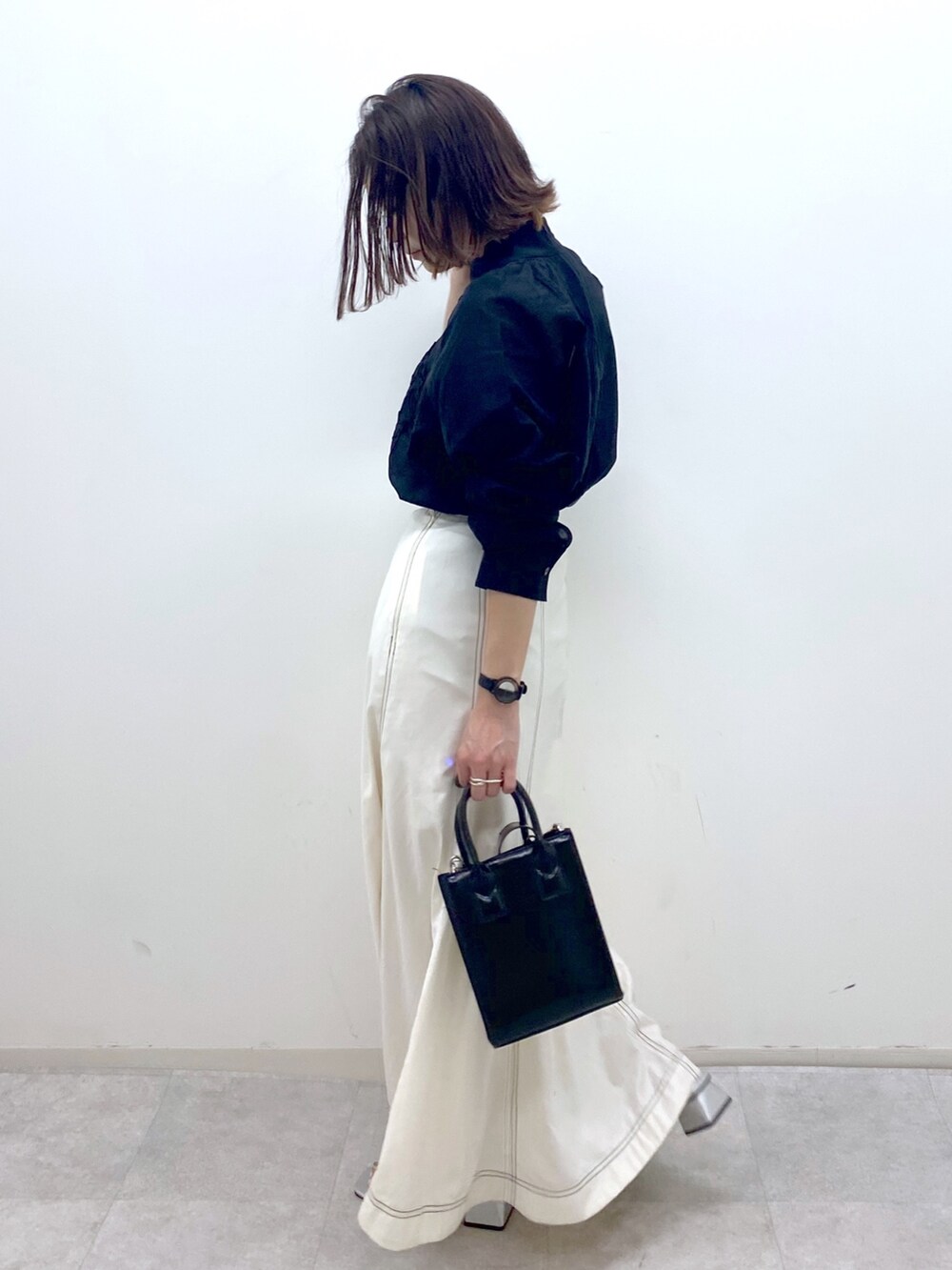 ホワイト系のスカート、シルバー系のサンダル、ブラック系のショルダーバッグを着用したレディースの夏コーディネートの4枚目の写真