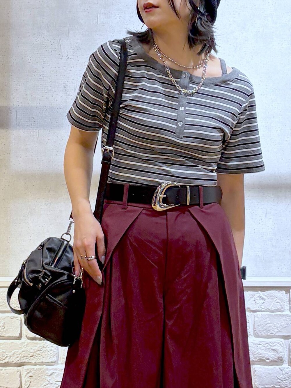 ブラック系のショルダーバッグ、レッド系のスラックス、グレー系のTシャツ/カットソーを着用したレディースの夏コーディネートの2枚目の写真