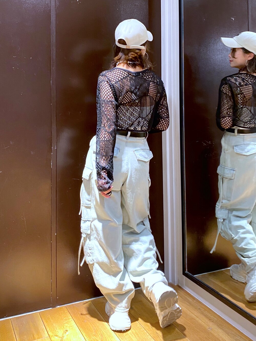 ブルー系のデニムパンツ、ホワイト系のスニーカー、ホワイト系のキャミソールを着用したレディースの夏コーディネートの6枚目の写真