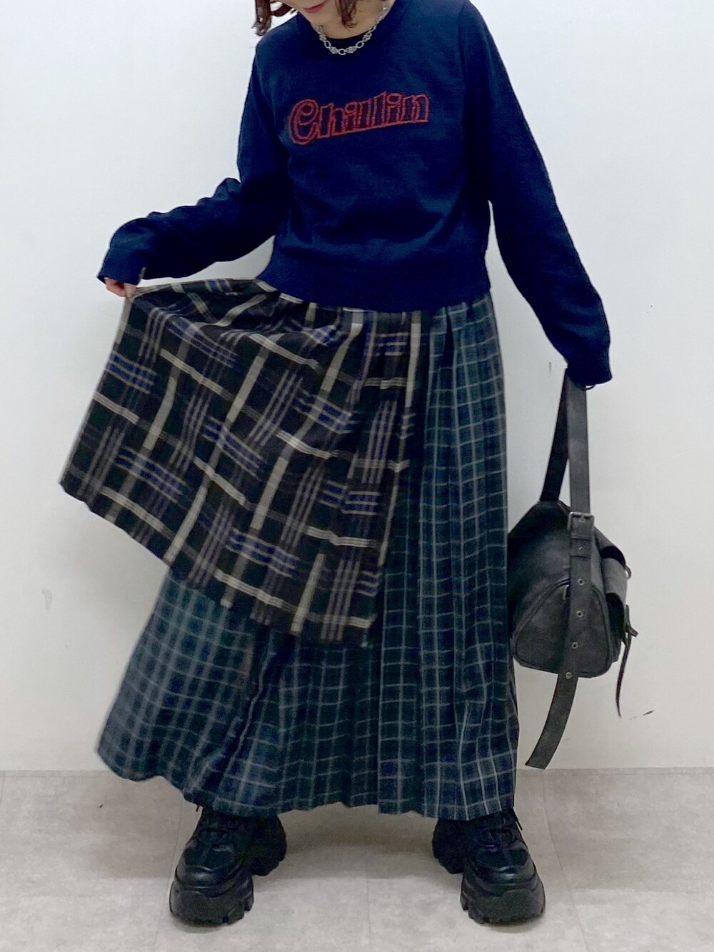 ブルー系のニット/セーター、ブルー系のスカート、ブラック系のショルダーバッグを着用したレディースの秋コーディネートの3枚目の写真