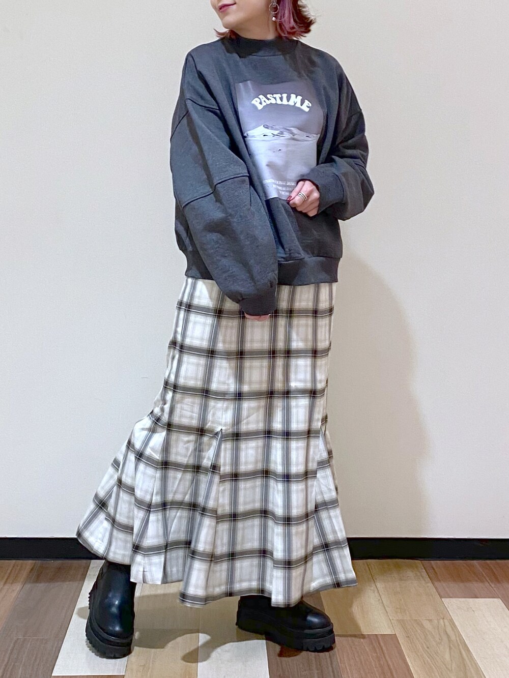 グレー系のスウェット、ホワイト系のスカート、ブラック系のブーツを着用したレディースの冬コーディネートの4枚目の写真