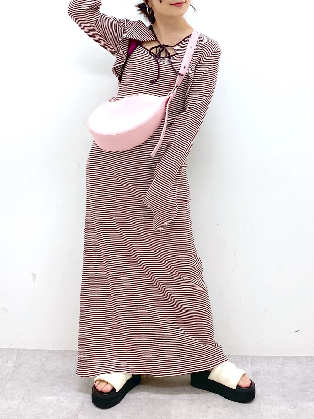 ブラウン系のワンピース、ピンク系のショルダーバッグ、ホワイト系のサンダルを着用したレディースの春コーディネートの5枚目の写真