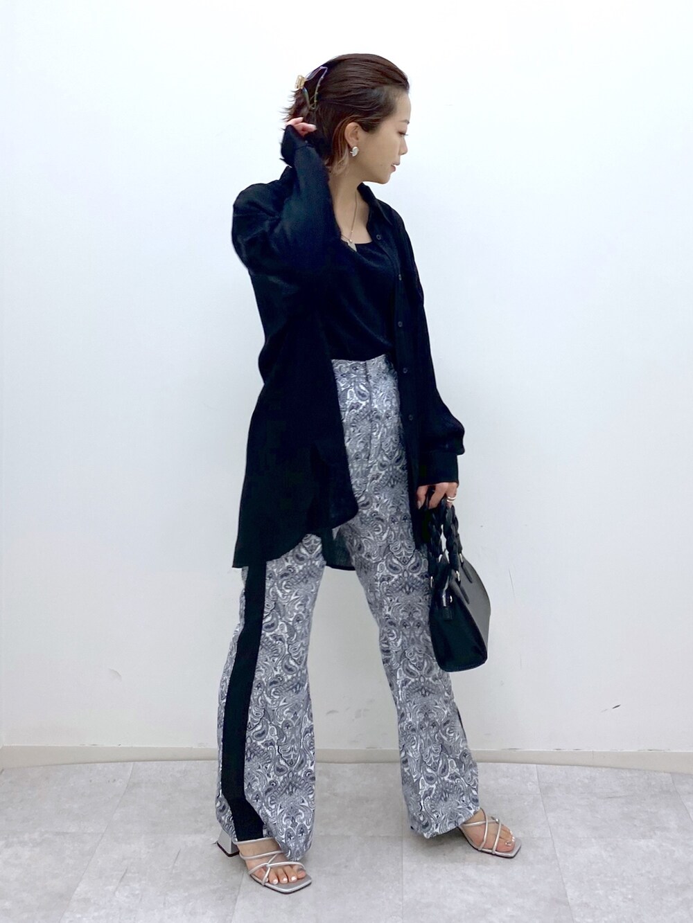 ブラック系のトップス、ホワイト系のその他パンツ、シルバー系のサンダルを着用したレディースの夏コーディネートの4枚目の写真