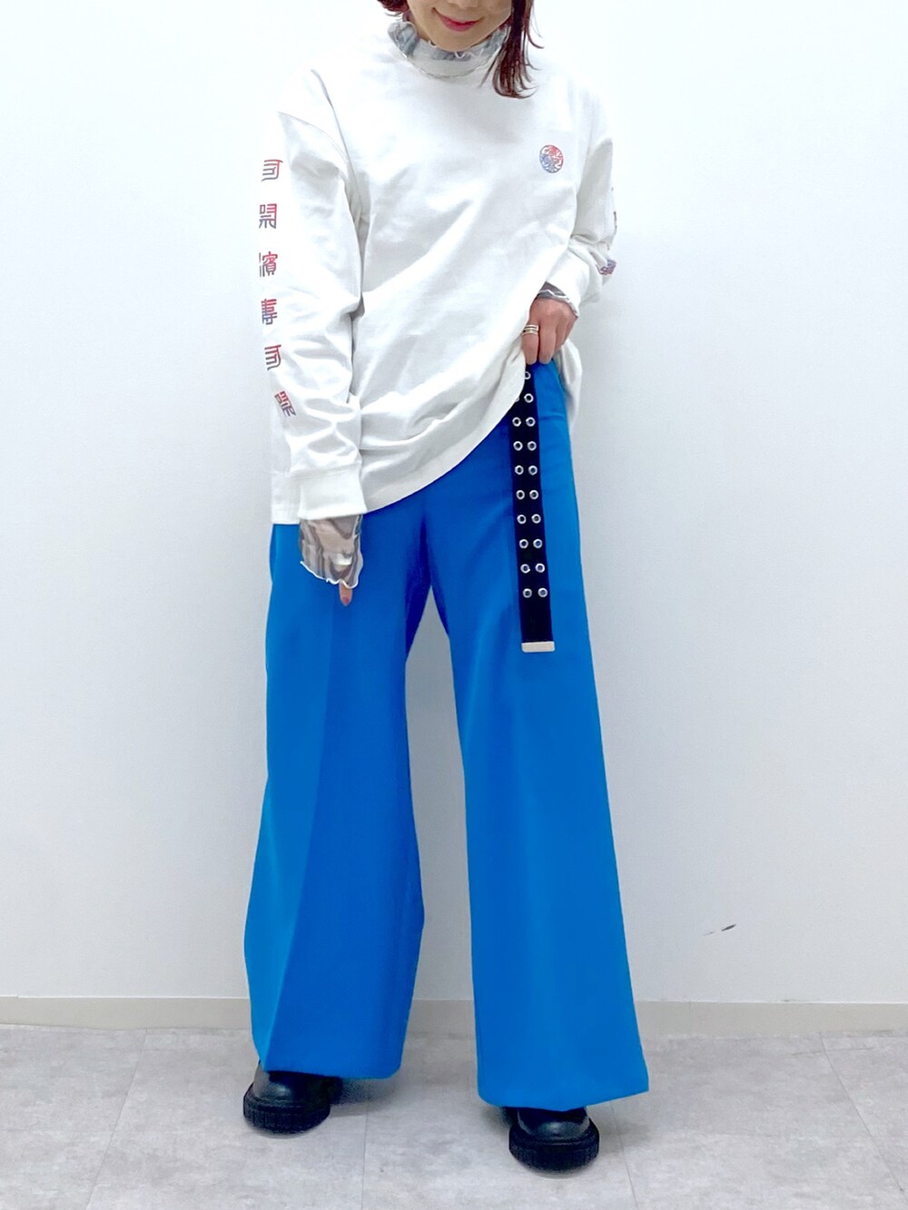 ホワイト系のTシャツ/カットソー、グリーン系のシャツ/ブラウス、ブルー系のスラックスを着用したレディースの春コーディネートの5枚目の写真