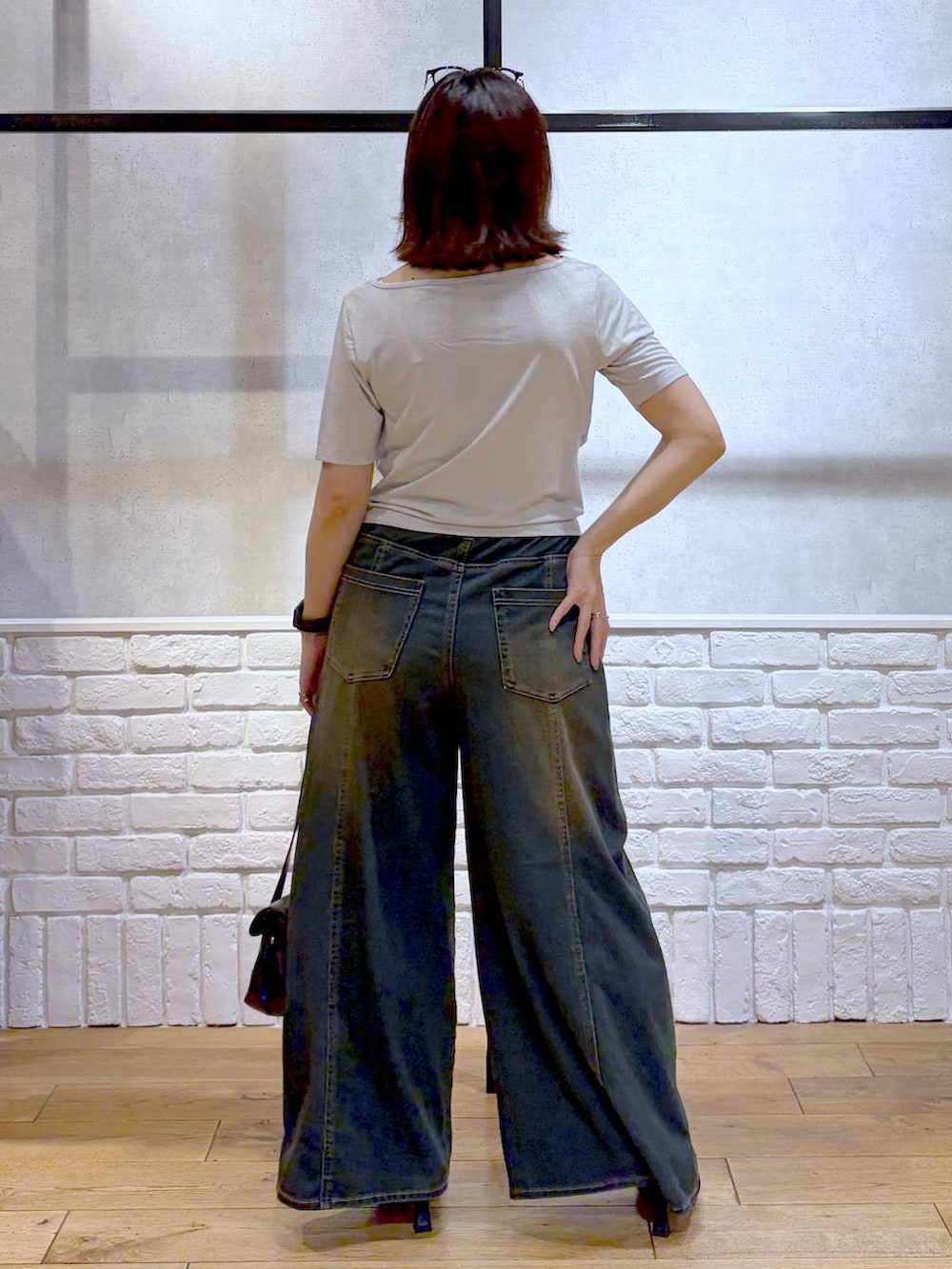 グリーン系のデニムパンツ、ブラック系のサンダル、ベージュ系のTシャツ/カットソーを着用したレディースの夏コーディネートの6枚目の写真