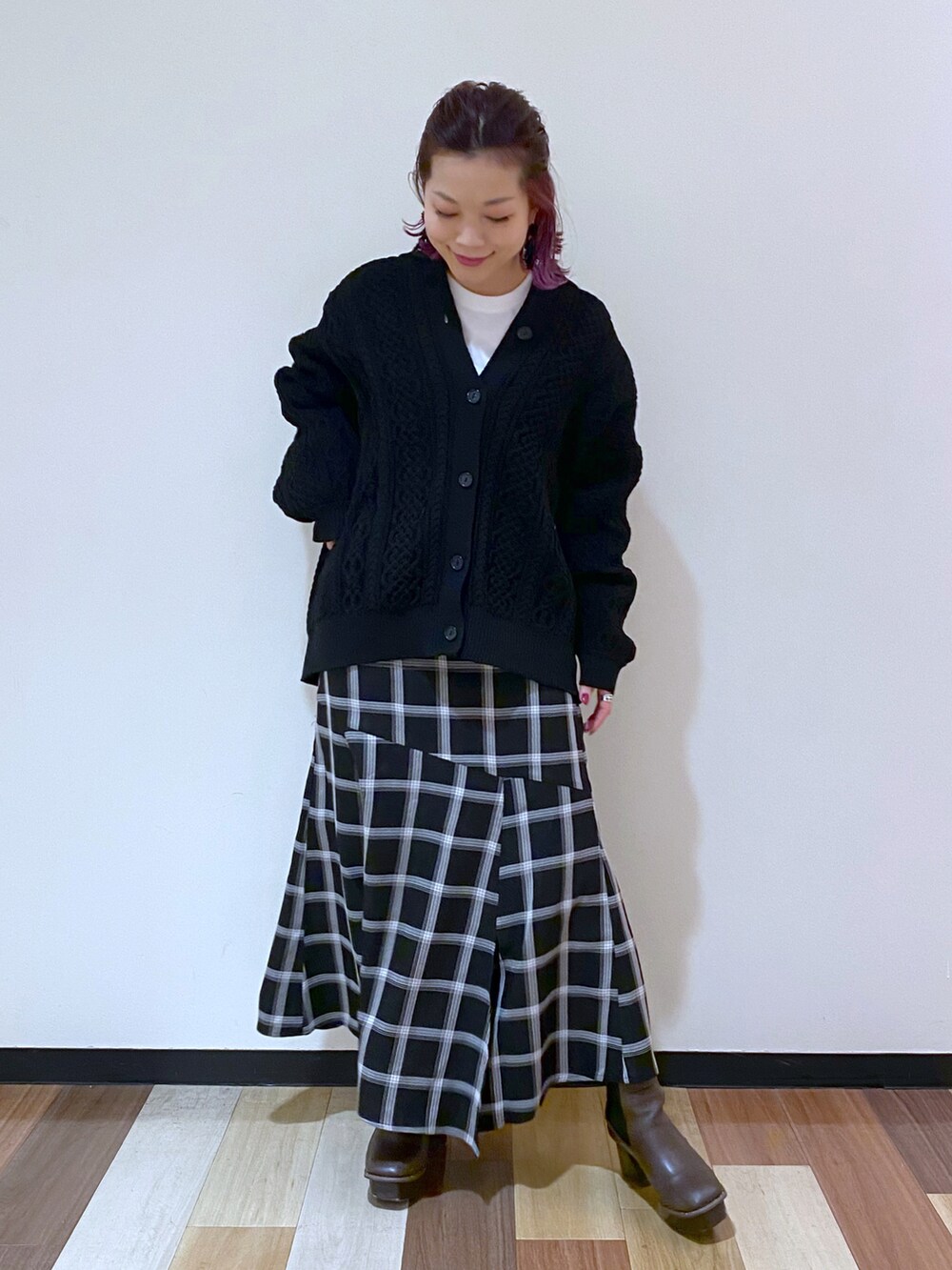 ブラウン系のブーツ、ブラック系のスカート、ブラック系のニット/セーターを着用したレディースの冬コーディネートの2枚目の写真