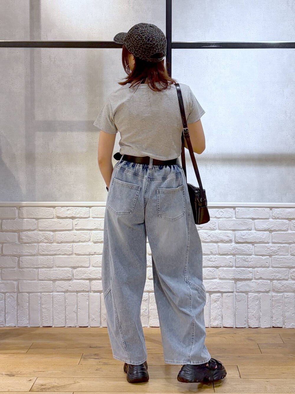 ブルー系のデニムパンツ、ブラック系のショルダーバッグ、ブラック系のサンダルを着用したレディースの春コーディネートの5枚目の写真