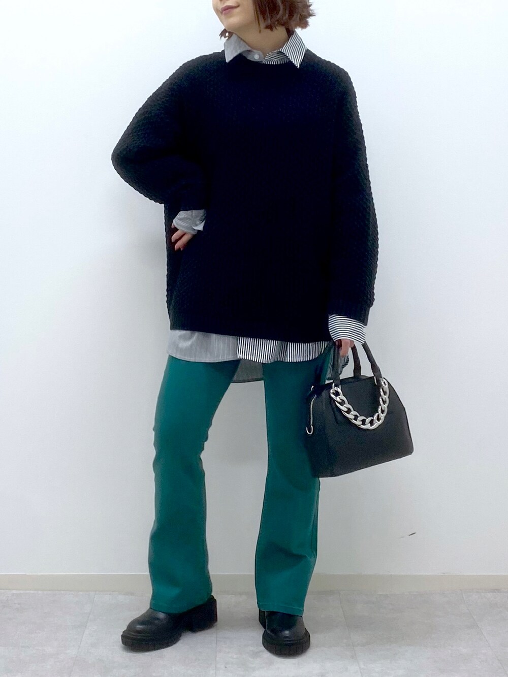 ブラック系のニット/セーター、ブラック系のシャツ/ブラウス、ブラック系のローファーを着用したレディースの春コーディネートの5枚目の写真