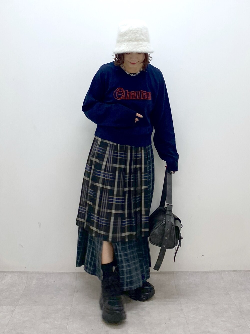 ブルー系のニット/セーター、ブルー系のスカート、ブラック系のショルダーバッグを着用したレディースの秋コーディネートの4枚目の写真