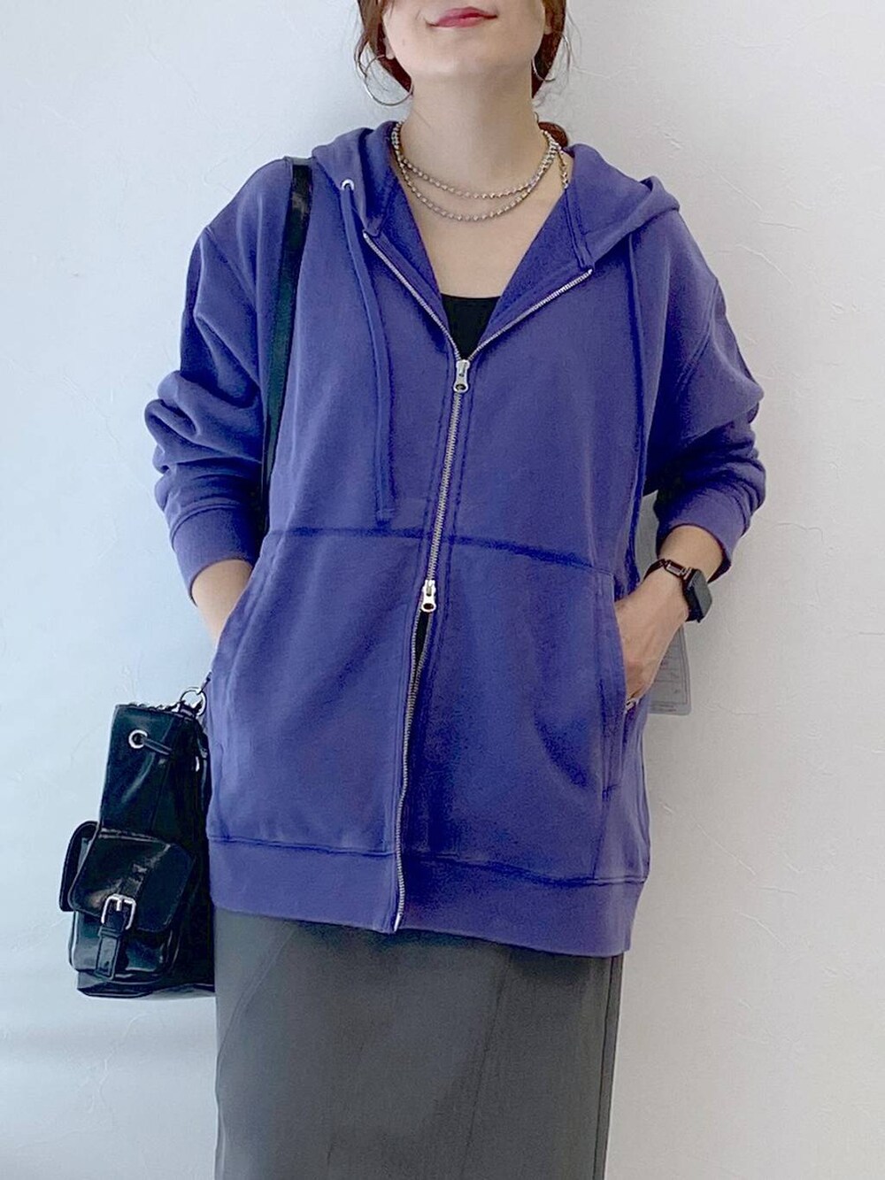 ブラック系のスニーカー、グレー系のスカート、ブラック系のショルダーバッグを着用したレディースの秋コーディネートの2枚目の写真