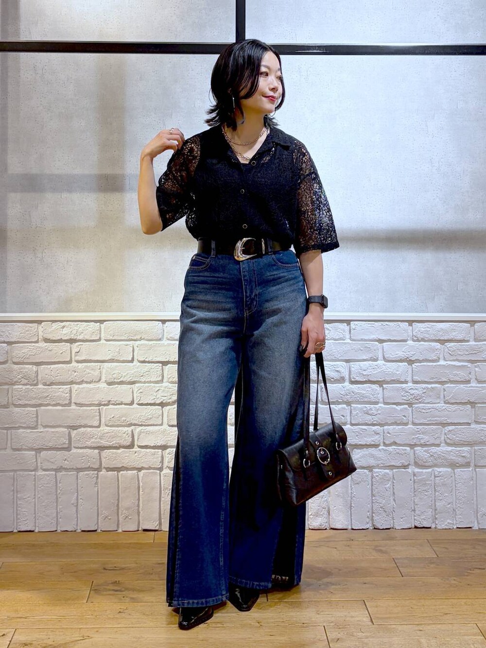 ブルー系のデニムパンツ、ブラック系のシャツ/ブラウス、ブラック系のショルダーバッグを着用したレディースの夏コーディネートの4枚目の写真