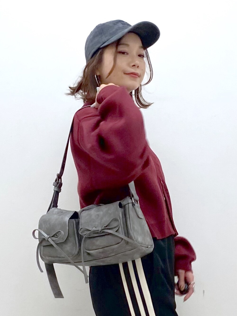 レッド系のニット/セーター、ブラック系のその他パンツ、ブラック系のブーツを着用したレディースの秋コーディネートの2枚目の写真