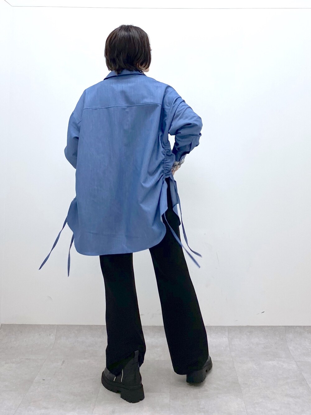 ブラック系のデニムパンツ、ブルー系のシャツ/ブラウス、ホワイト系のニット/セーターを着用したレディースの冬コーディネートの3枚目の写真
