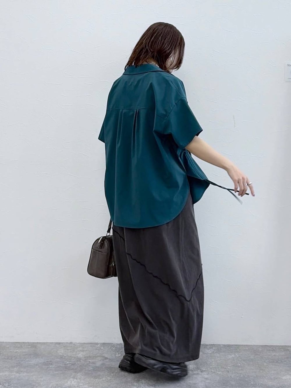 ブラック系のワンピース、グレー系のショルダーバッグ、グリーン系のシャツ/ブラウスを着用したレディースの春コーディネートの7枚目の写真