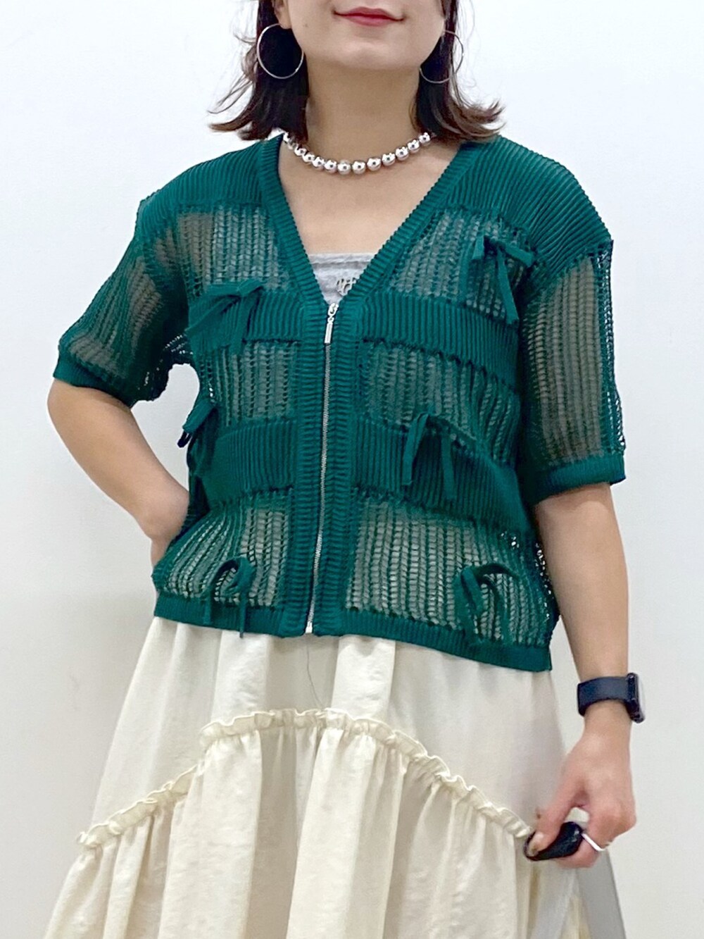 ホワイト系のスカート、グレー系のタンクトップ、シルバー系のショルダーバッグを着用したレディースの夏コーディネートの2枚目の写真