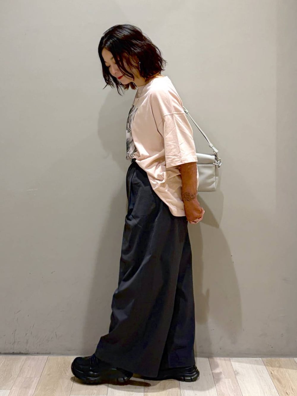 ブラック系のローファー、グレー系のショルダーバッグ、ピンク系のTシャツ/カットソーを着用したレディースの夏コーディネートの7枚目の写真