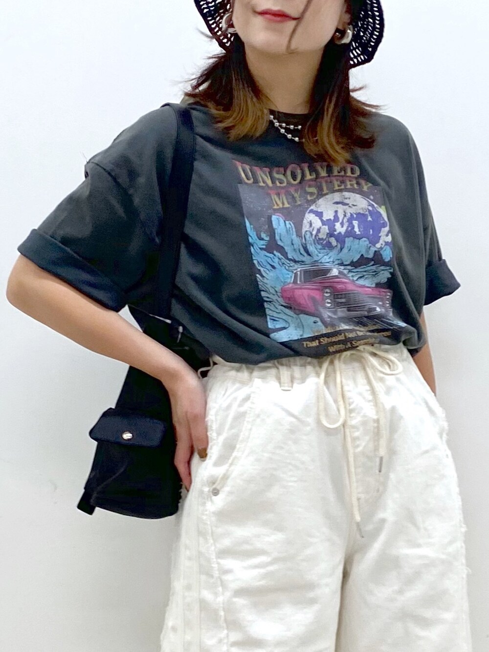 ホワイト系のデニムパンツ、ブラック系のショルダーバッグ、グレー系のTシャツ/カットソーを着用したレディースの春コーディネートの2枚目の写真