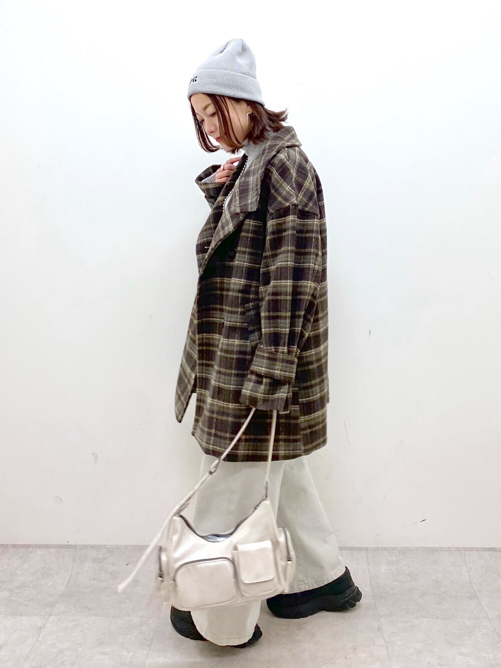 ブラウン系のテーラードジャケット、グレー系のデニムパンツ、ホワイト系のショルダーバッグを着用したレディースの冬コーディネートの7枚目の写真