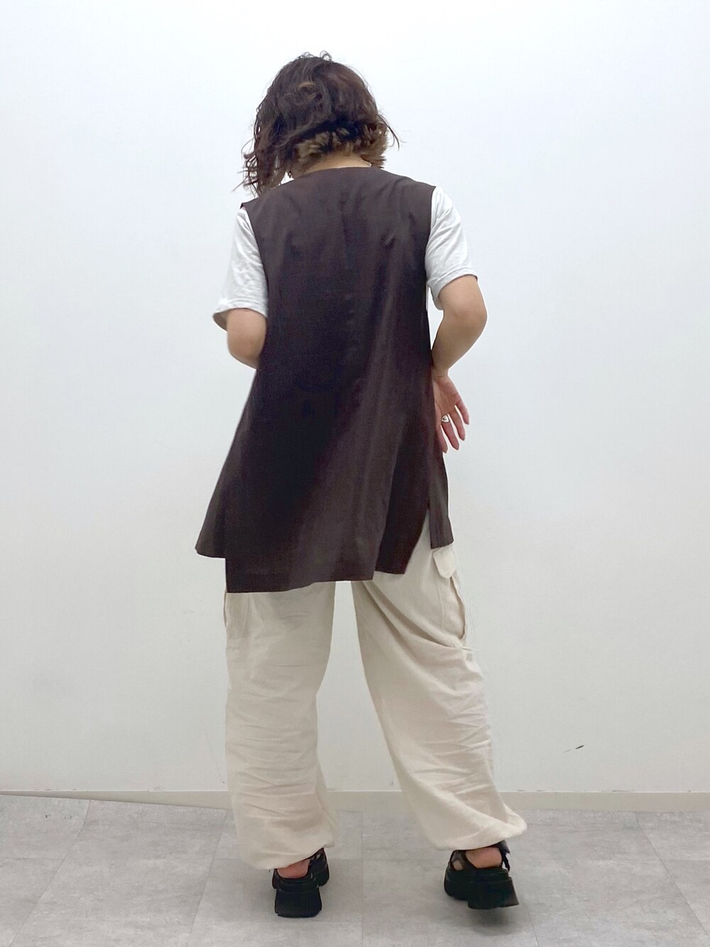 ホワイト系のカーゴパンツ、ブラック系のサンダル、ベージュ系のTシャツ/カットソーを着用したレディースの夏コーディネートの3枚目の写真