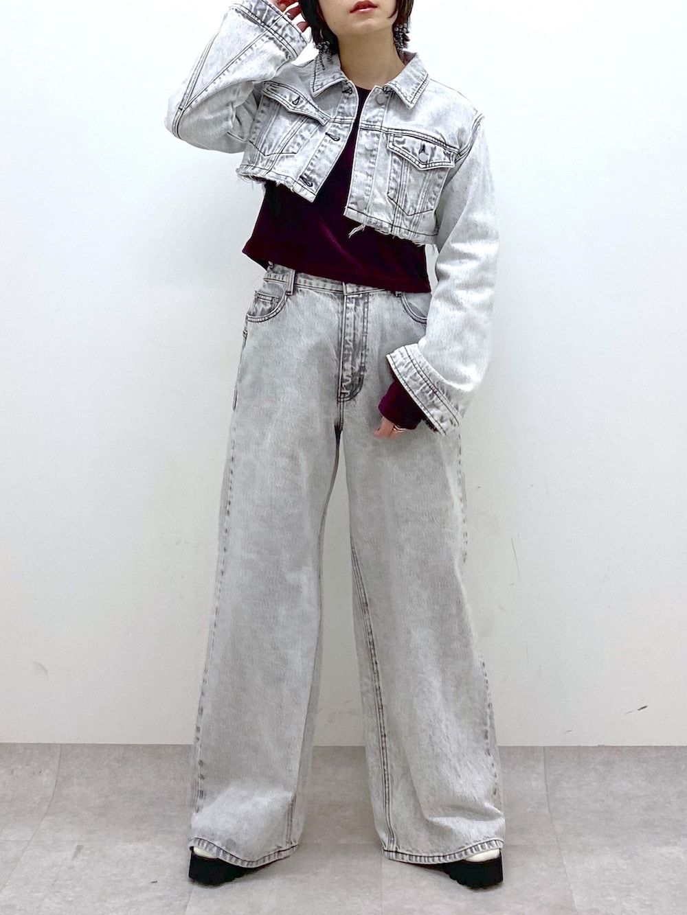 グレー系のデニムパンツ、グレー系のデニムジャケット、レッド系のTシャツ/カットソーを着用したレディースの冬コーディネートの4枚目の写真