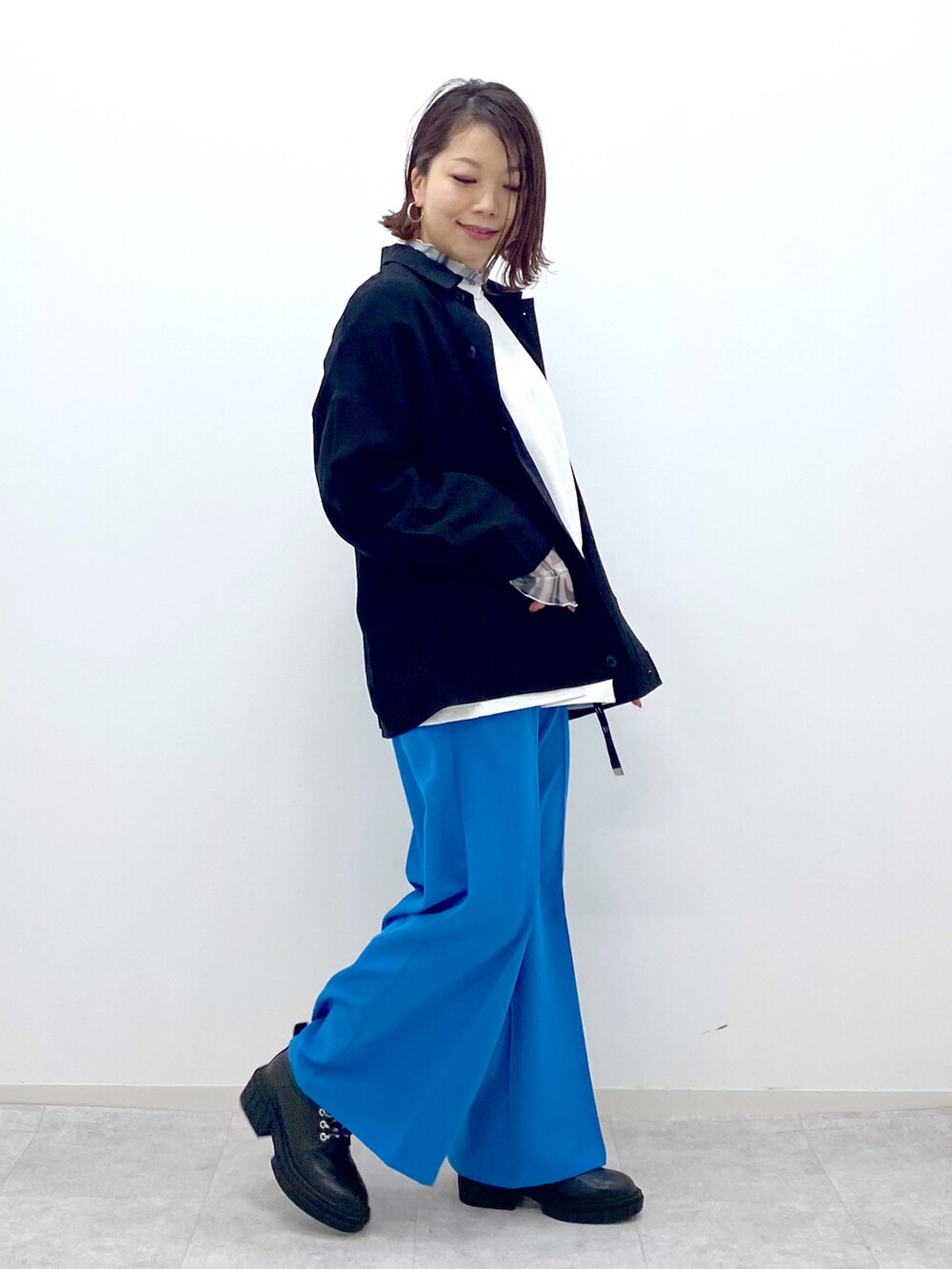 ホワイト系のTシャツ/カットソー、グリーン系のシャツ/ブラウス、ブルー系のスラックスを着用したレディースの春コーディネートの2枚目の写真