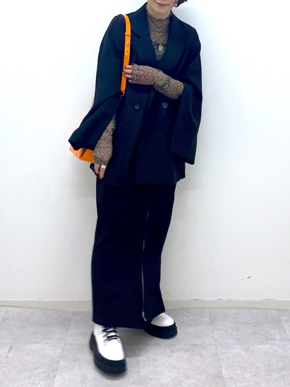 ブラック系のスカート、ホワイト系のブーツ、ブラック系のジャケット/アウターを着用したレディースの秋コーディネートの5枚目の写真