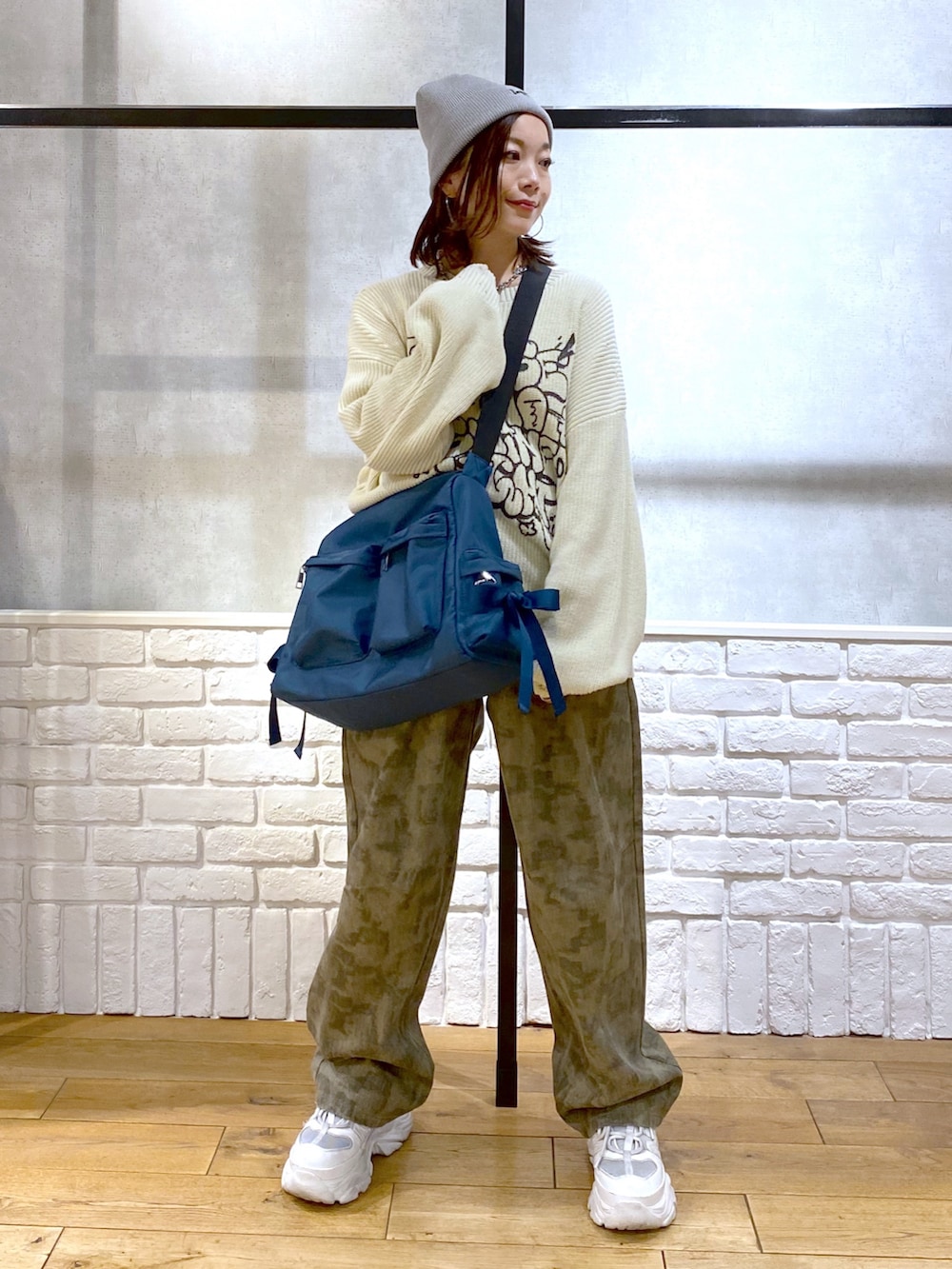 ホワイト系のニット/セーター、ブルー系のショルダーバッグ、その他のデニムパンツを着用したレディースの春コーディネートの8枚目の写真