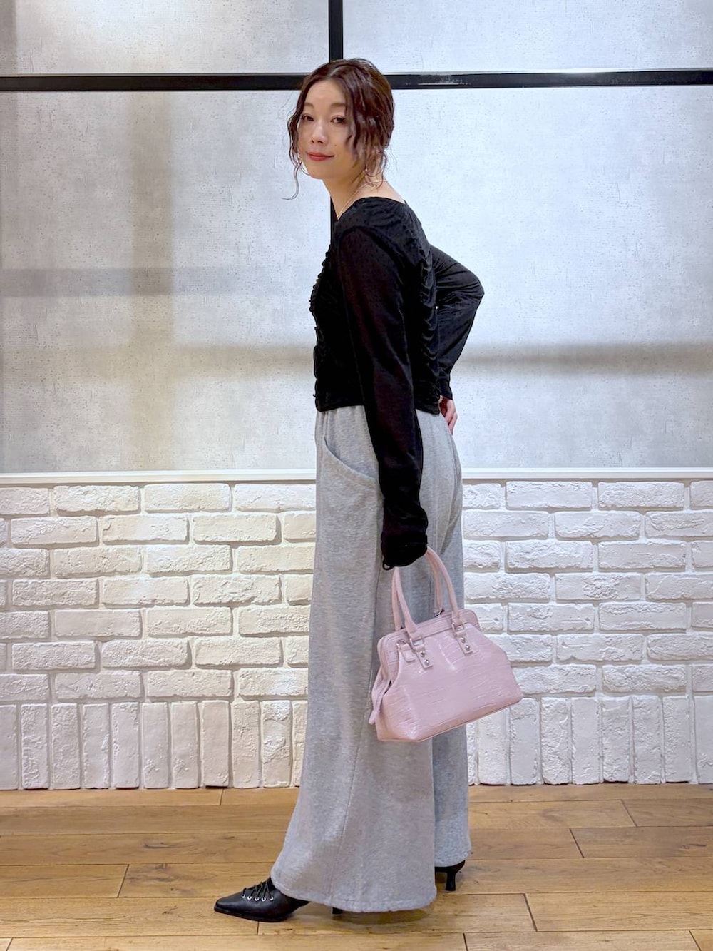 ホワイト系のキャミソール、ピンク系のハンドバッグ、グレー系のスウェットパンツを着用したレディースの春コーディネートの5枚目の写真