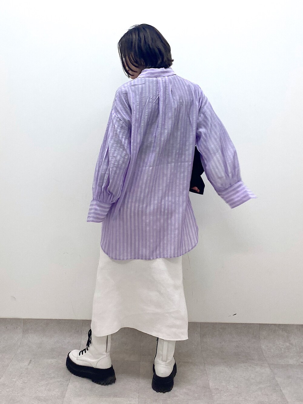 パープル系のトップス、ホワイト系のスカート、ホワイト系のシューズを着用したレディースの春コーディネートの4枚目の写真