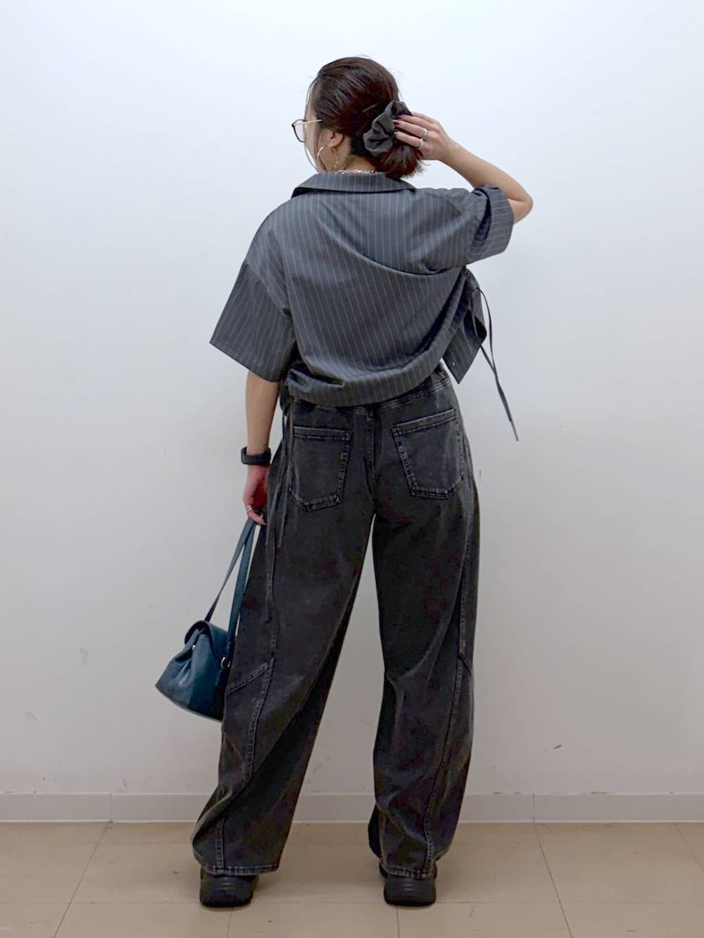 ブラック系のデニムパンツ、ブラック系のサンダル、グレー系のシャツ/ブラウスを着用したレディースの夏コーディネートの6枚目の写真