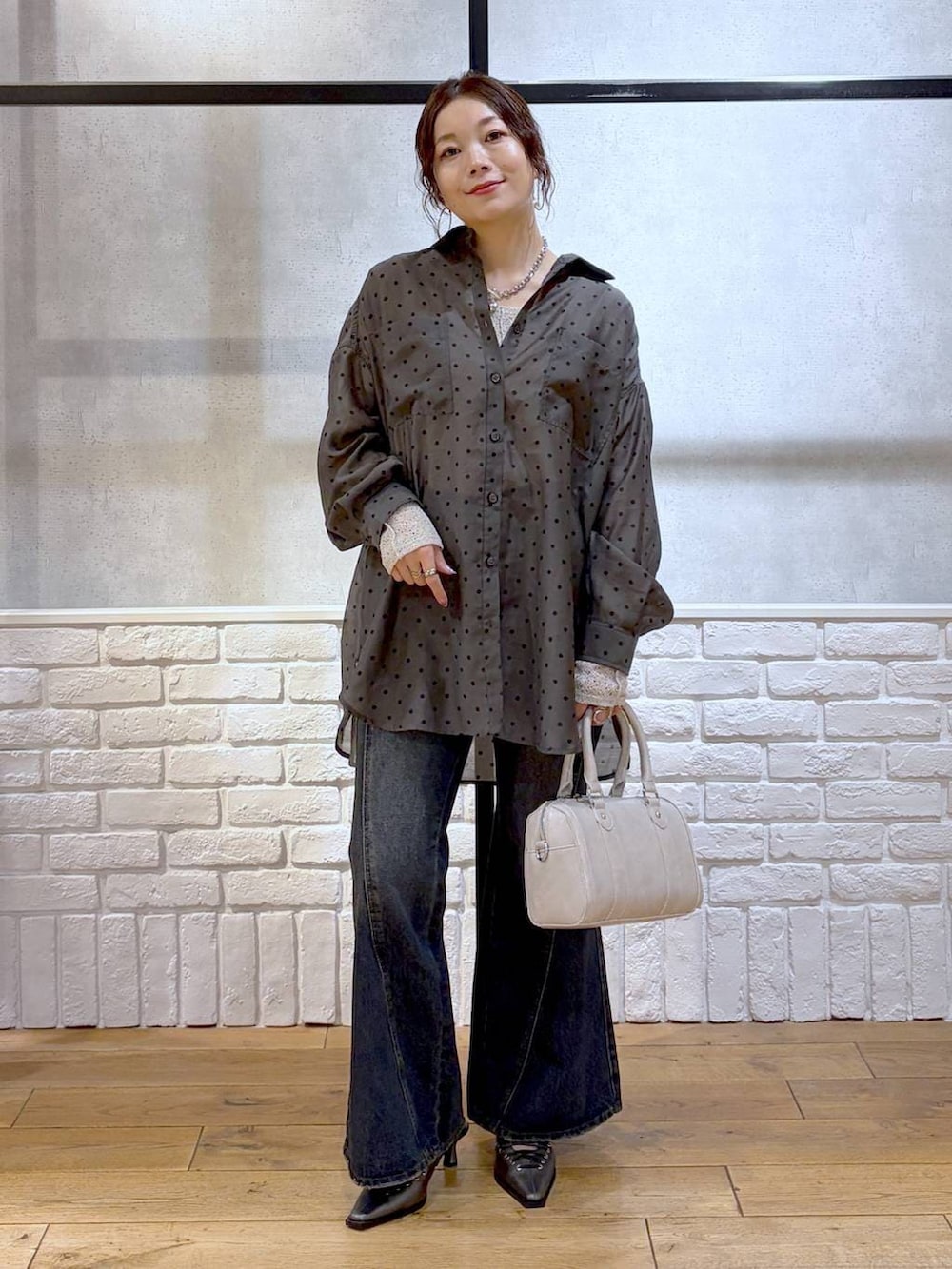 ブルー系のデニムパンツ、ホワイト系のボストンバッグ、ブラウン系のサンダルを着用したレディースの春コーディネートの5枚目の写真