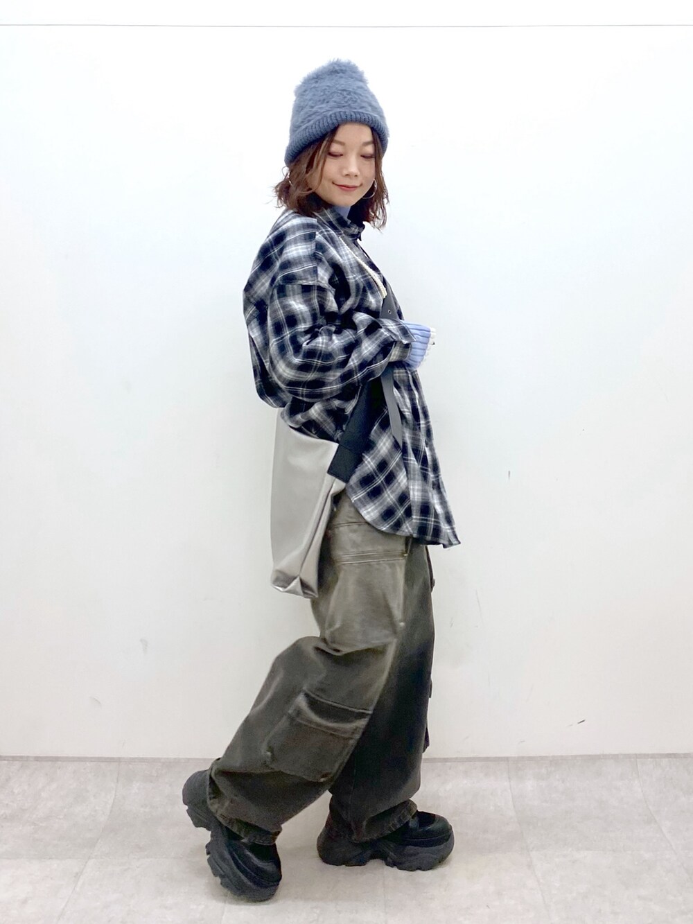 ブラック系のシャツ/ブラウス、シルバー系のトートバッグ、ブルー系のニット/セーターを着用したレディースの冬コーディネートの8枚目の写真