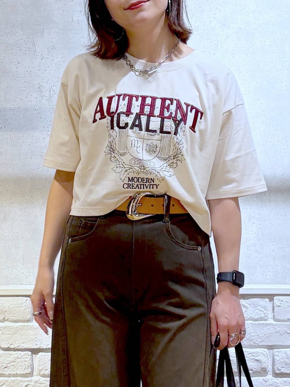 ブラウン系のデニムパンツ、ホワイト系のTシャツ/カットソー、ブラック系のサンダルを着用したレディースの夏コーディネートの2枚目の写真