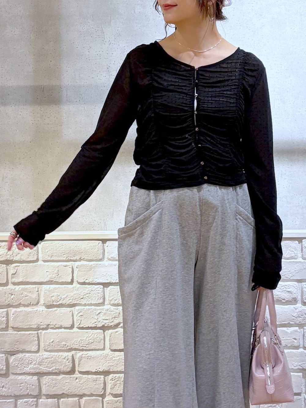 ピンク系のハンドバッグ、グレー系のスウェットパンツ、ブラック系のサンダルを着用したレディースの春コーディネートの3枚目の写真