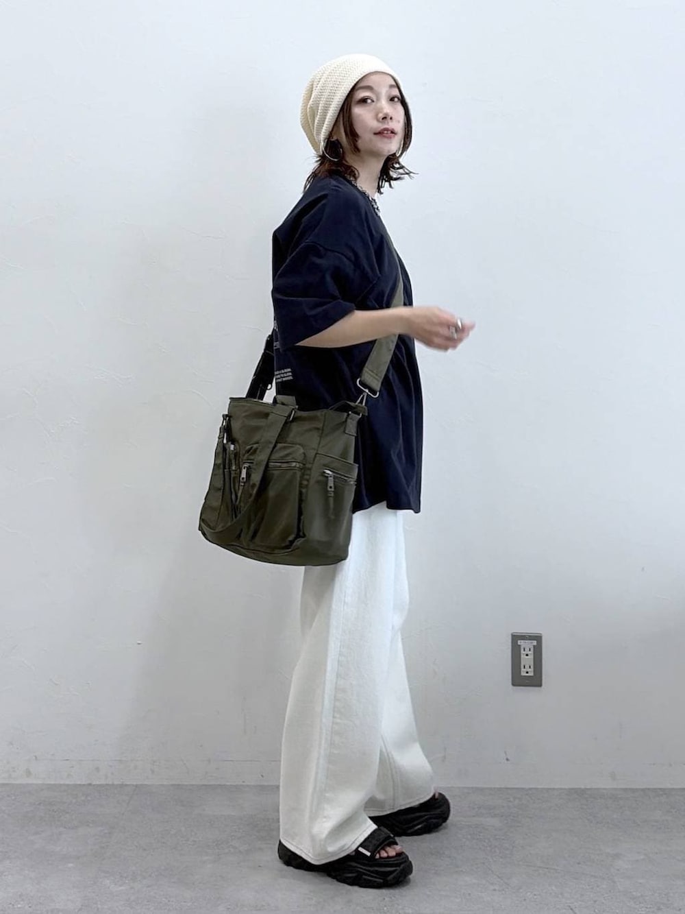 グリーン系のボストンバッグ、ホワイト系のスラックス、ブルー系のTシャツ/カットソーを着用したレディースの春コーディネートの5枚目の写真