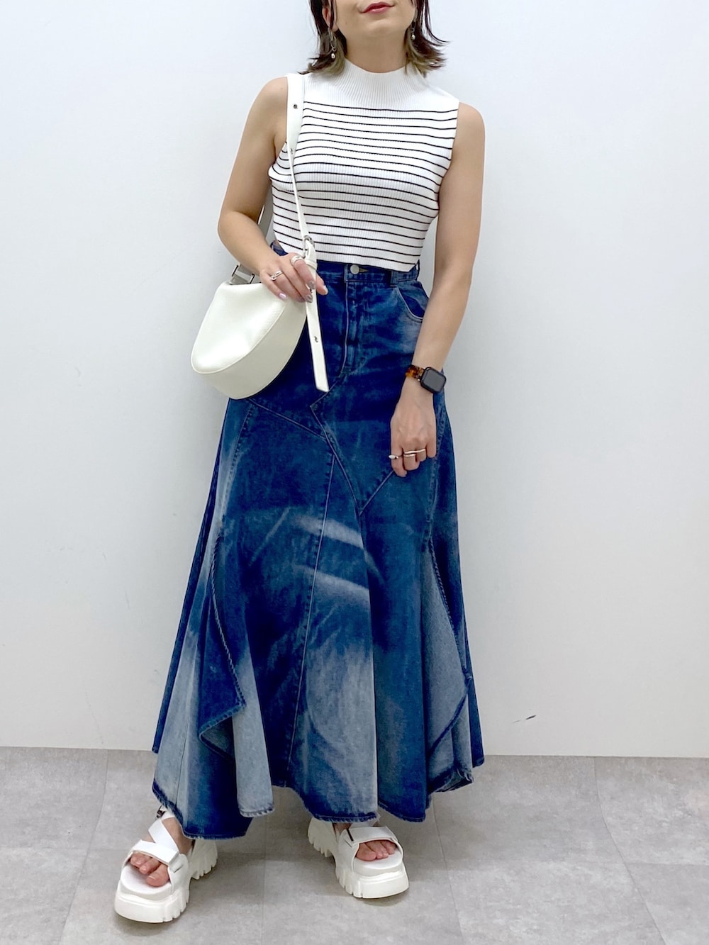 ホワイト系のショルダーバッグ、ブルー系のスカート、ホワイト系のTシャツ/カットソーを着用したレディースの夏コーディネートの6枚目の写真