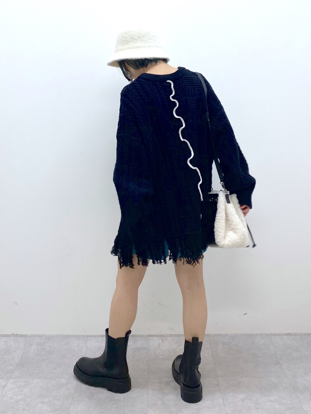 ブラック系のトップス、ブルー系のその他パンツ、ホワイト系のバッグを着用したレディースの秋コーディネートの3枚目の写真