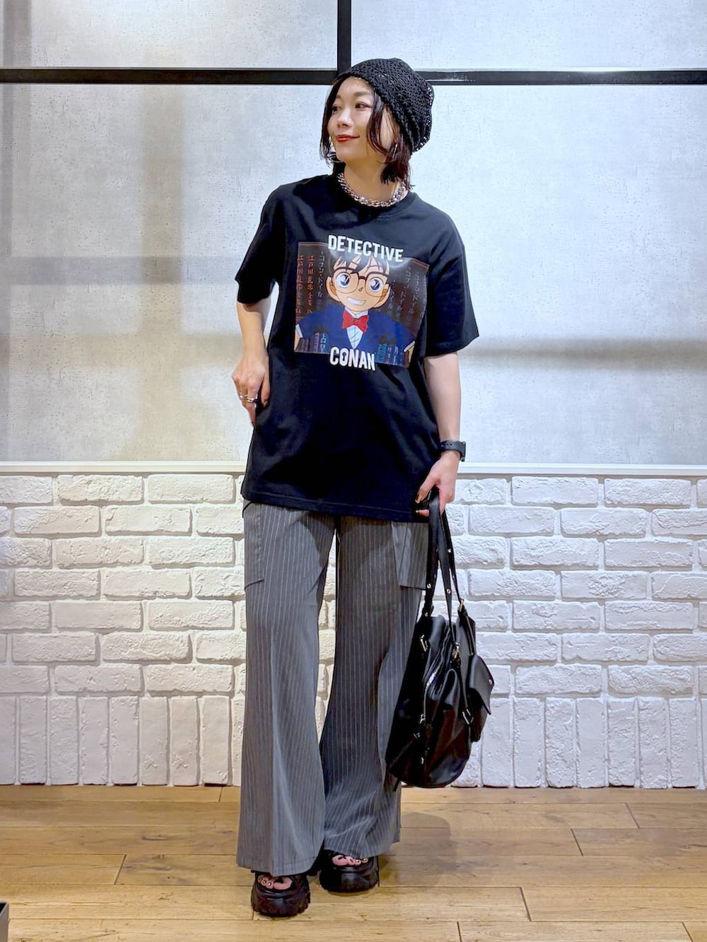 ブラック系のサンダル、ブラック系のボストンバッグ、ブラック系のTシャツ/カットソーを着用したレディースの春コーディネートの9枚目の写真