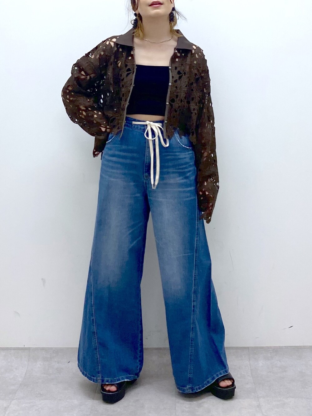 ブルー系のデニムパンツ、ブラウン系のカーディガン/ボレロ、ブラック系のキャミソールを着用したレディースの夏コーディネートの8枚目の写真