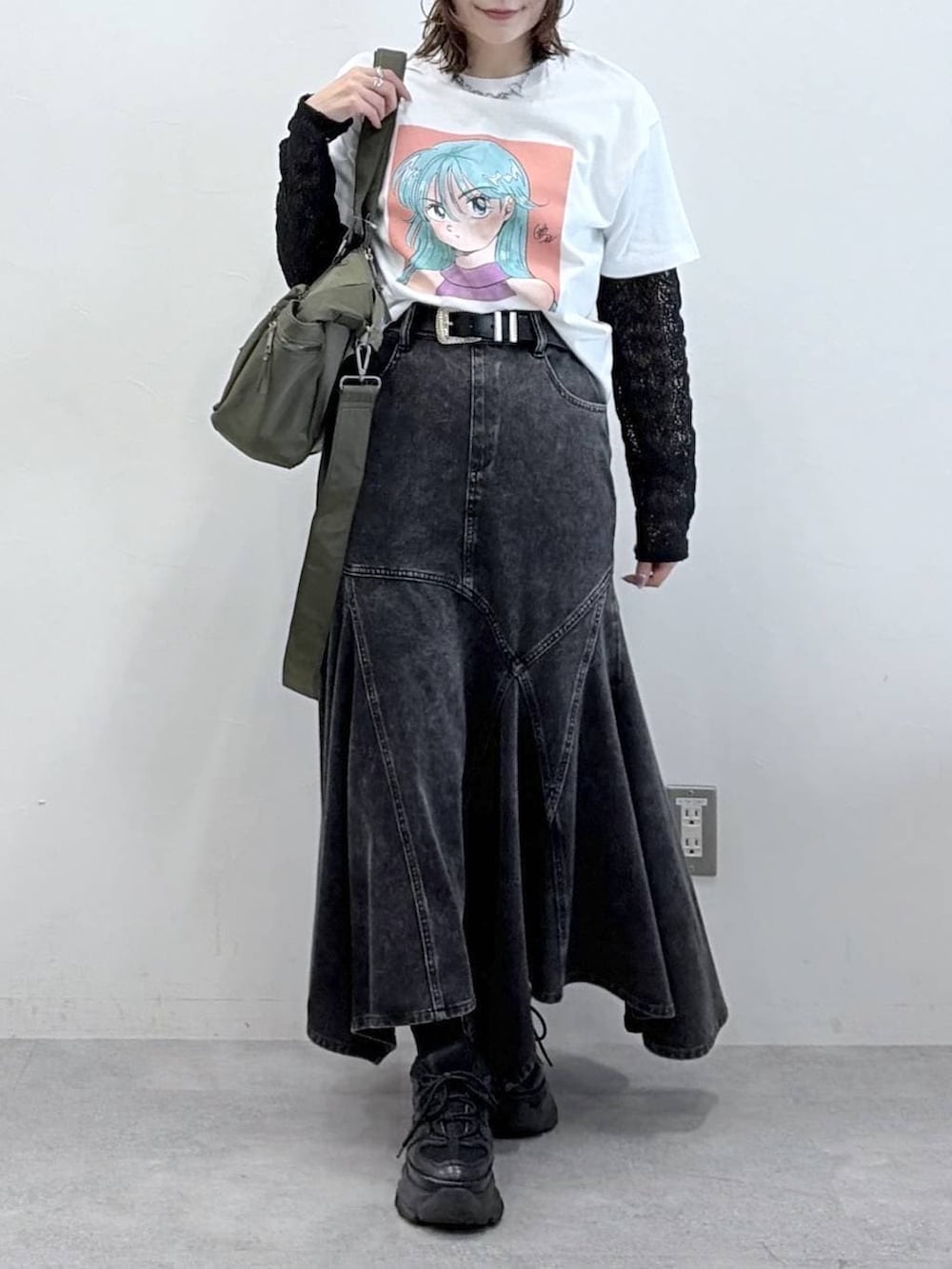 ブラック系のスニーカー、グリーン系のボストンバッグ、ブラック系のデニムスカートを着用したレディースの春コーディネートの3枚目の写真